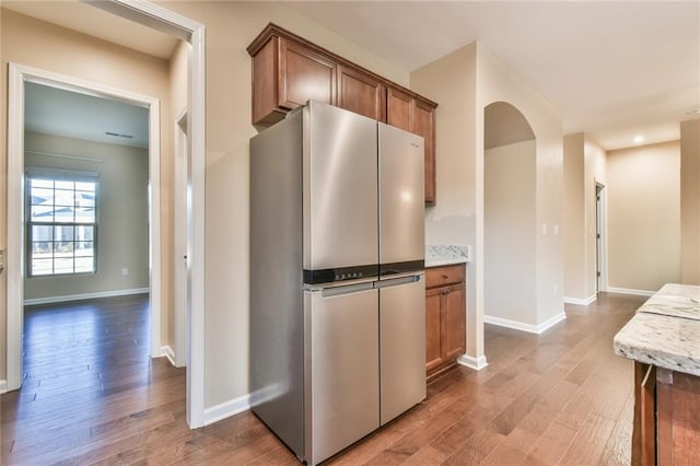 kitchen with stainless steel fridge and hardwood / wood-style flooring