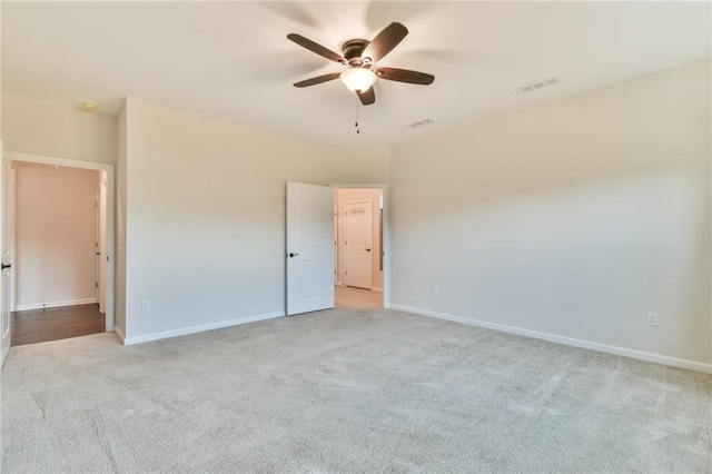 spare room featuring light colored carpet and ceiling fan