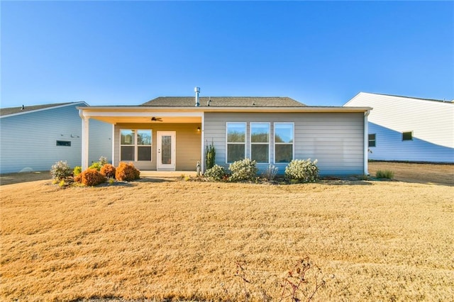 back of house with a lawn and ceiling fan