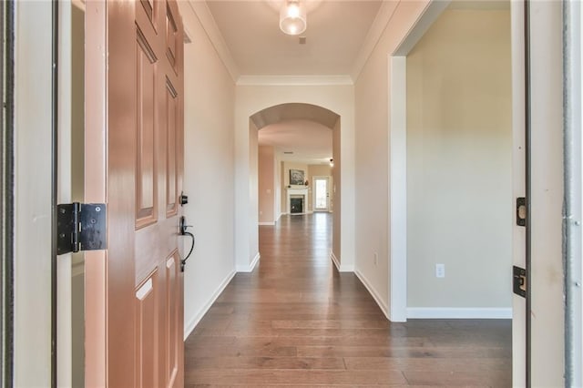 corridor with dark wood-type flooring and ornamental molding