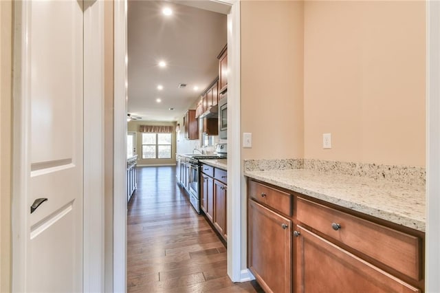 kitchen featuring dark hardwood / wood-style flooring, gas stove, and light stone counters