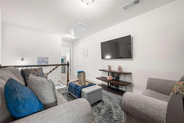 living room with visible vents, baseboards, and attic access