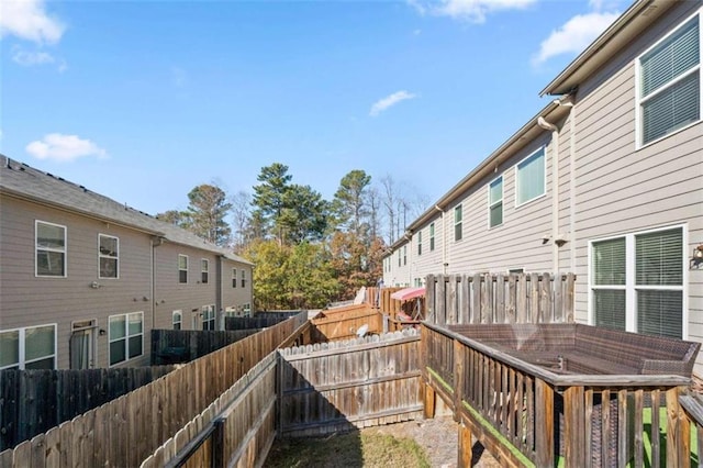 wooden terrace with a fenced backyard