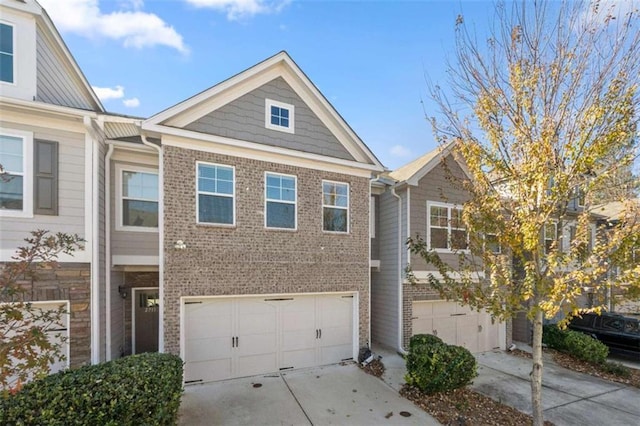 view of property with brick siding, driveway, and an attached garage