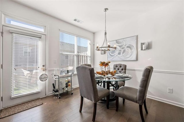 dining space featuring visible vents, baseboards, a notable chandelier, and dark wood-style floors