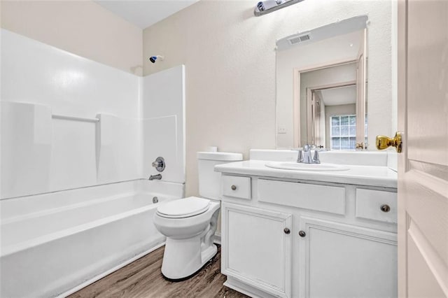 full bathroom with vanity, wood-type flooring, tub / shower combination, and toilet