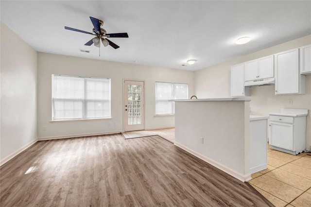 kitchen with white cabinetry, light wood-type flooring, and ceiling fan