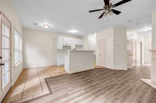 unfurnished living room featuring ceiling fan and light hardwood / wood-style floors