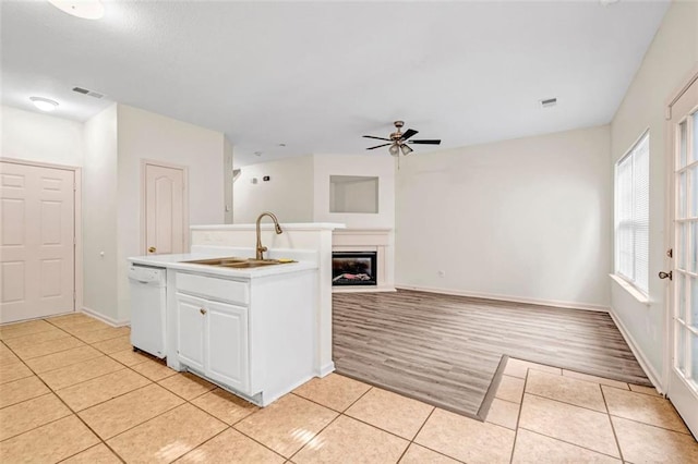 kitchen with white cabinetry, light wood-type flooring, white dishwasher, sink, and ceiling fan