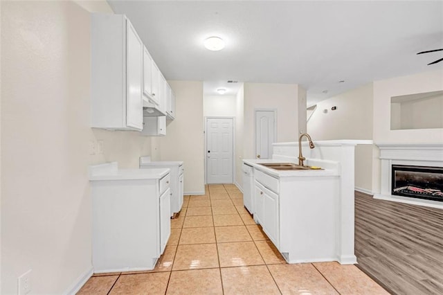 kitchen featuring white appliances, sink, light tile patterned floors, and white cabinets