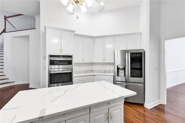 385 Windermere Cir, Newnan, GA 30265 - kitchen with stainless steel appliances, a towering ceiling, dark wood-style flooring, light stone countertops, and ceiling fan