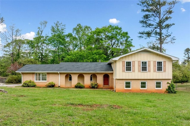 tri-level home featuring board and batten siding and a front lawn