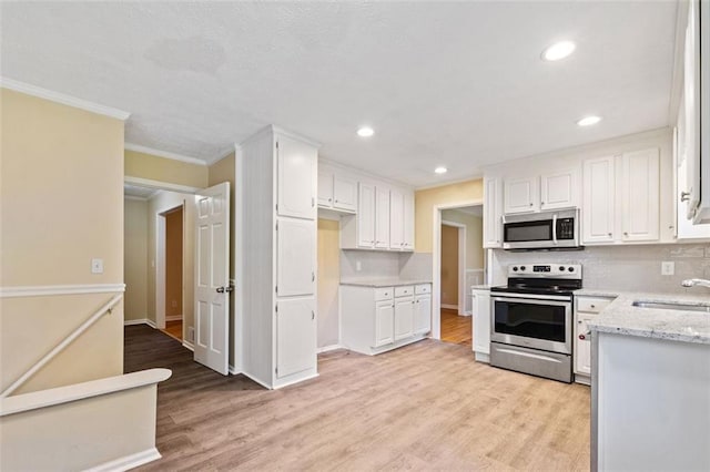 kitchen featuring decorative backsplash, a sink, appliances with stainless steel finishes, and crown molding