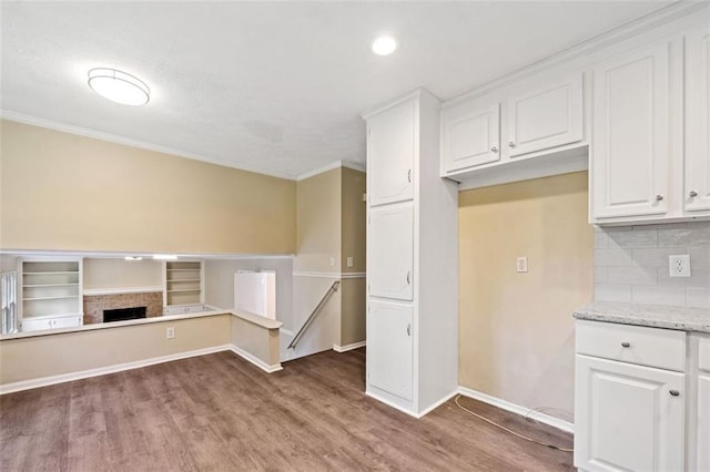 kitchen featuring tasteful backsplash, wood finished floors, and white cabinetry