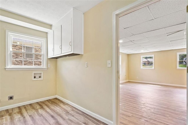 laundry room with hookup for an electric dryer, cabinet space, hookup for a washing machine, and light wood-style flooring