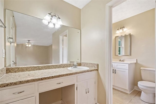 bathroom with toilet, baseboards, a ceiling fan, tile patterned flooring, and vanity