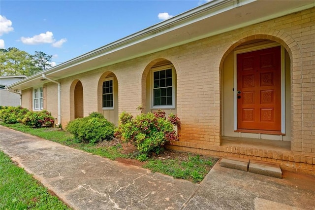 doorway to property with brick siding