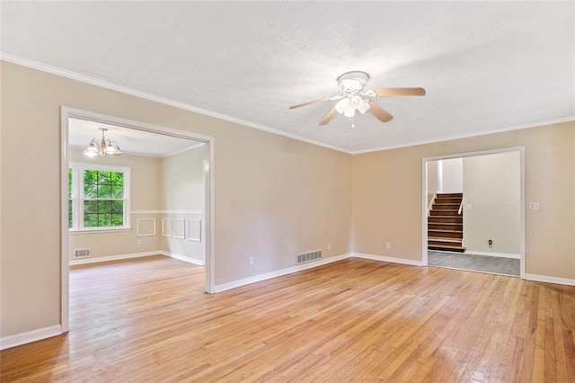 spare room with light wood-type flooring, visible vents, ceiling fan with notable chandelier, stairway, and ornamental molding