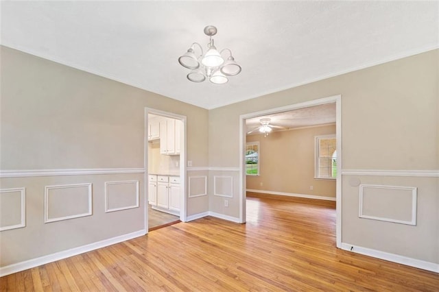 unfurnished room with baseboards, light wood-style floors, a chandelier, and crown molding