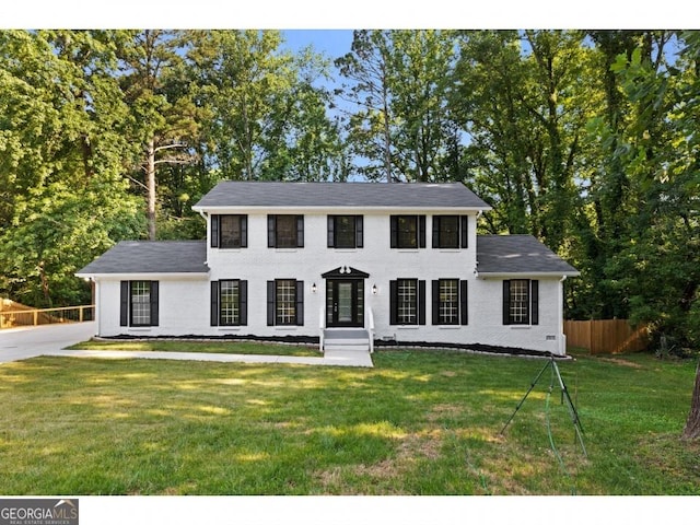 colonial house featuring a front lawn