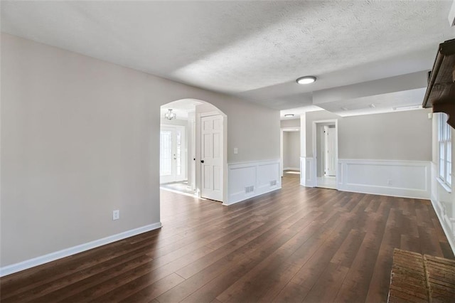 unfurnished living room with dark hardwood / wood-style floors and a textured ceiling