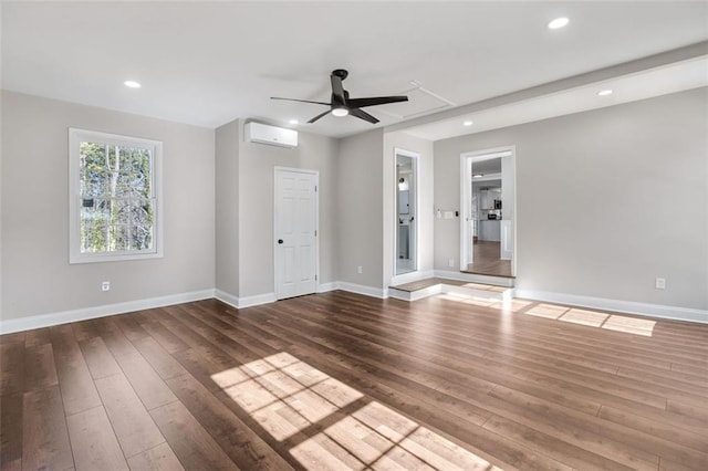 unfurnished room with a wall mounted air conditioner, ceiling fan, and dark wood-type flooring