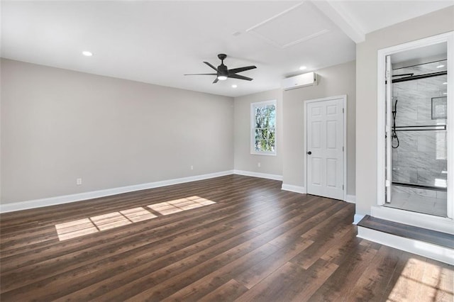 spare room featuring dark hardwood / wood-style floors, an AC wall unit, and ceiling fan