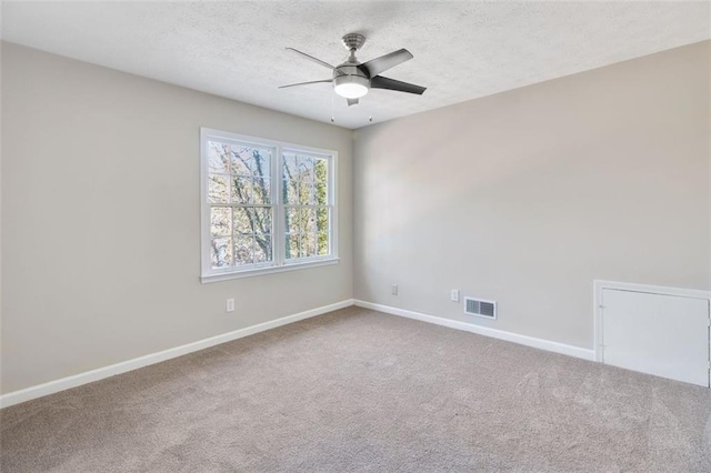 spare room featuring carpet, ceiling fan, and a textured ceiling