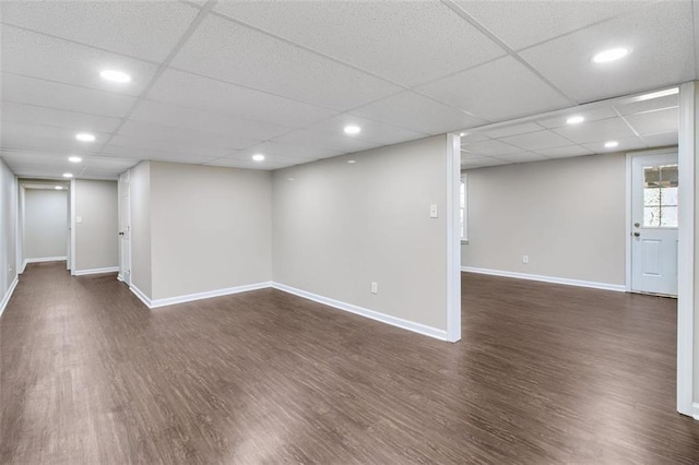 basement featuring dark hardwood / wood-style flooring and a drop ceiling