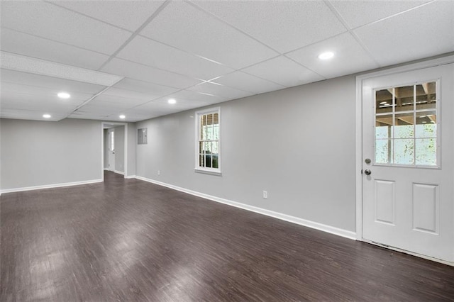 basement featuring a drop ceiling and dark hardwood / wood-style flooring