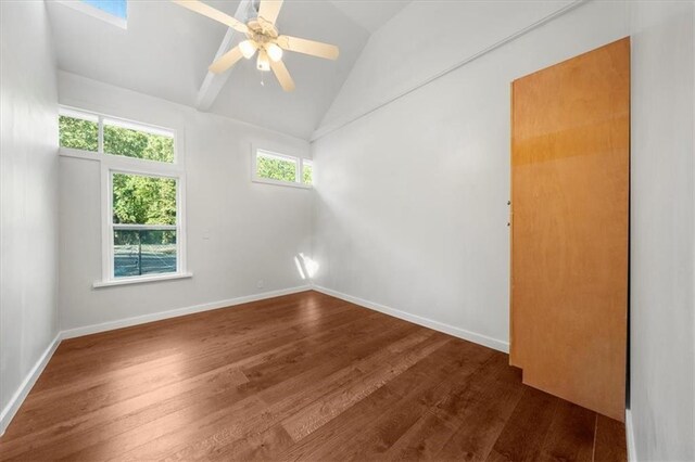 unfurnished room with a wealth of natural light, vaulted ceiling, and wood-type flooring