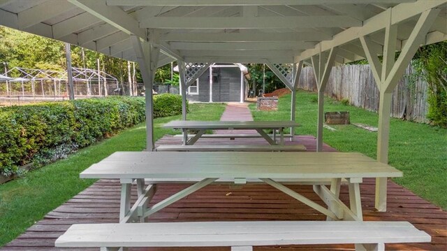 exterior space featuring an outbuilding, a wooden deck, and a lawn