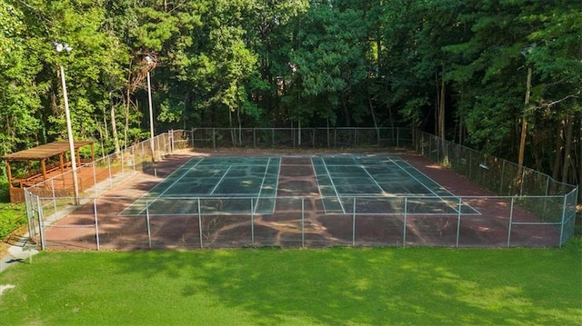 view of tennis court featuring a yard