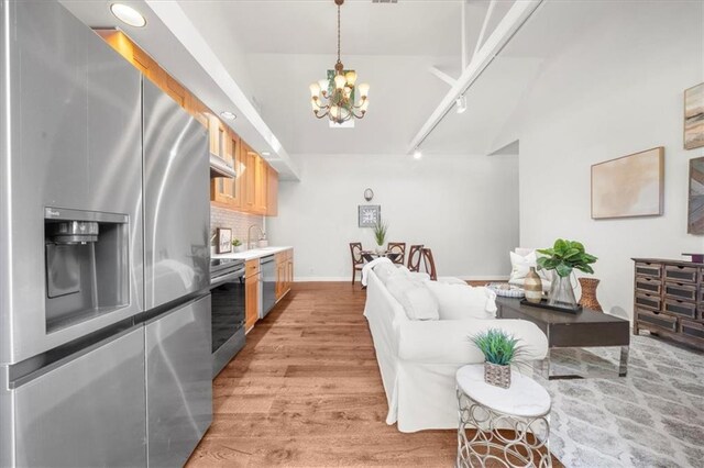 living room featuring sink, a notable chandelier, and hardwood / wood-style floors