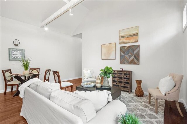 living room with beamed ceiling, high vaulted ceiling, hardwood / wood-style floors, and track lighting