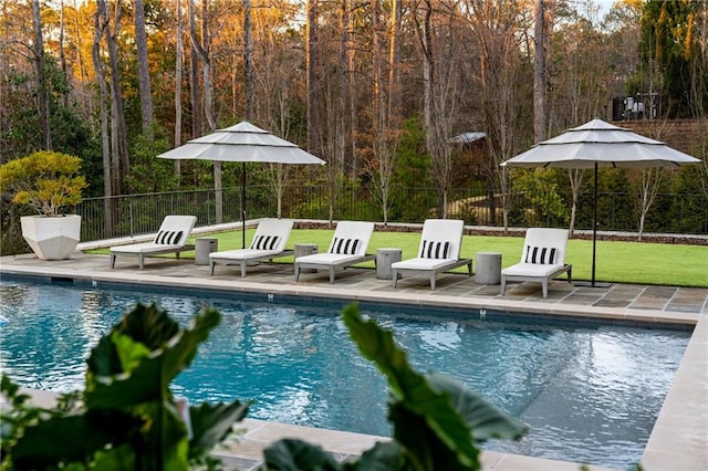 view of swimming pool with a patio area, fence, a fenced in pool, and a lawn