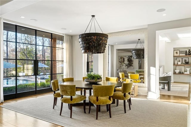 dining space with floor to ceiling windows, recessed lighting, wood finished floors, and a chandelier