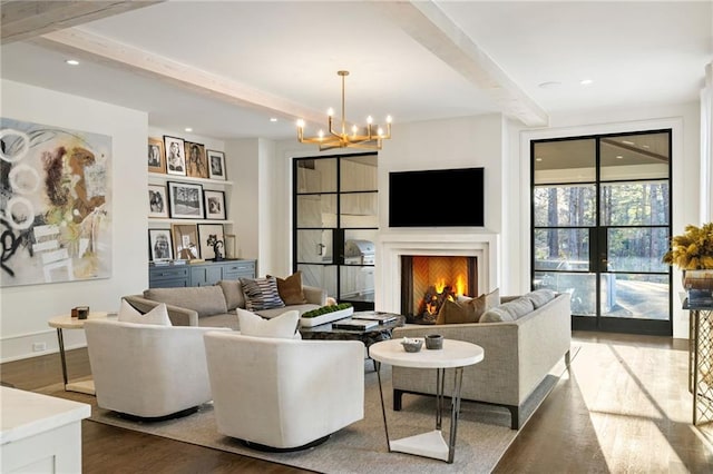 living area with beamed ceiling, a notable chandelier, dark wood-style floors, recessed lighting, and a lit fireplace