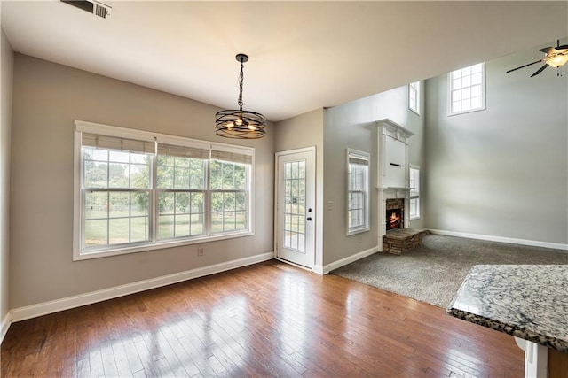 entrance foyer featuring ceiling fan with notable chandelier, dark hardwood / wood-style floors, and a wealth of natural light