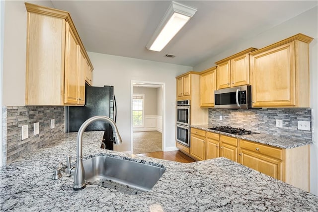 kitchen featuring decorative backsplash, light brown cabinets, sink, and black appliances