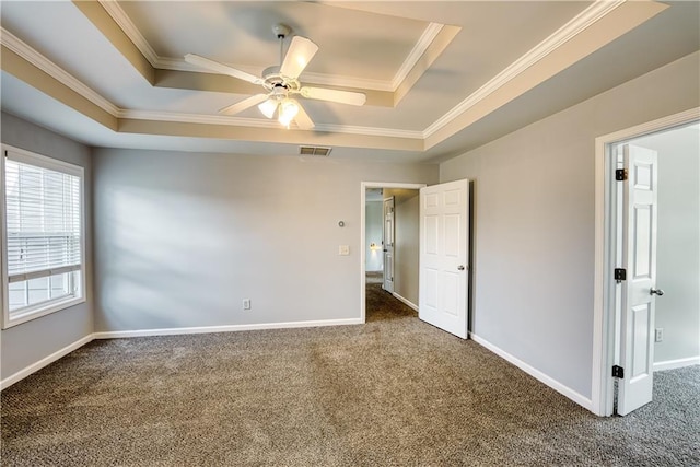 spare room with carpet flooring, ceiling fan, a raised ceiling, and ornamental molding