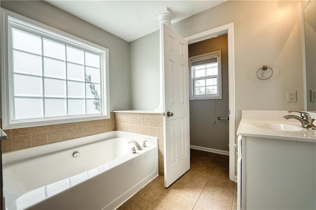 bathroom featuring tile patterned floors, vanity, and a tub to relax in