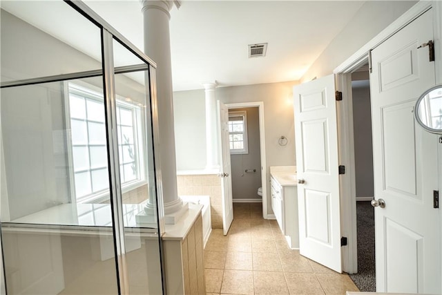 full bathroom with ornate columns, vanity, tile patterned flooring, shower with separate bathtub, and toilet