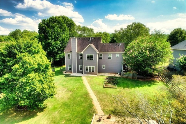 rear view of property featuring a lawn