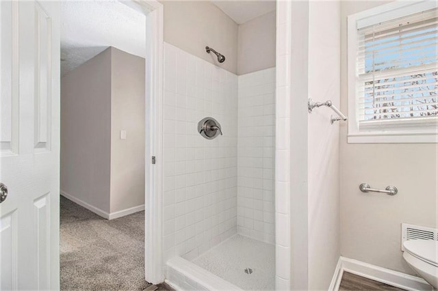 bathroom featuring toilet and tiled shower