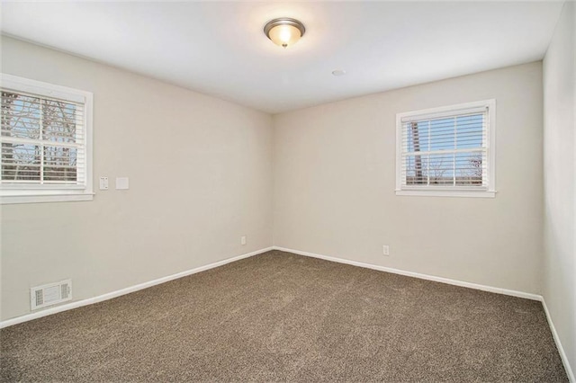 carpeted spare room featuring plenty of natural light