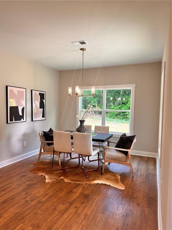 101 Red Oak Ln, Carrollton, GA 30116 - dining space featuring dark wood-style floors, a chandelier, and baseboards