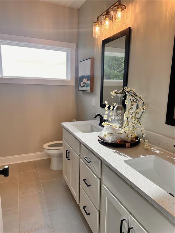 101 Red Oak Ln, Carrollton, GA 30116 - bathroom featuring tile patterned flooring, toilet, double vanity, and baseboards