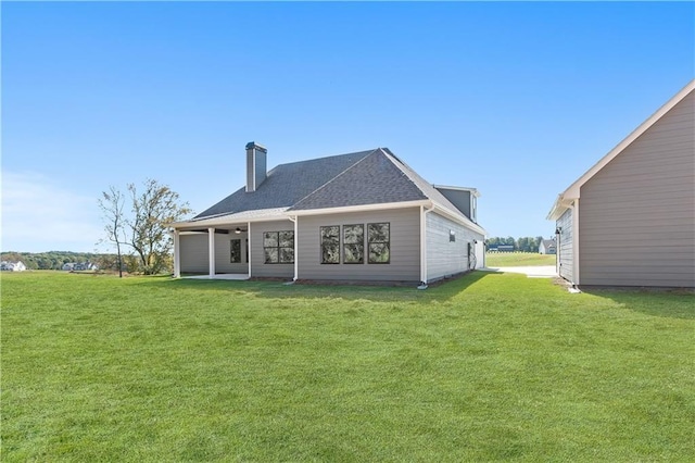 101 Red Oak Ln, Carrollton, GA 30116 - back of house featuring a chimney, a lawn, and roof with shingles