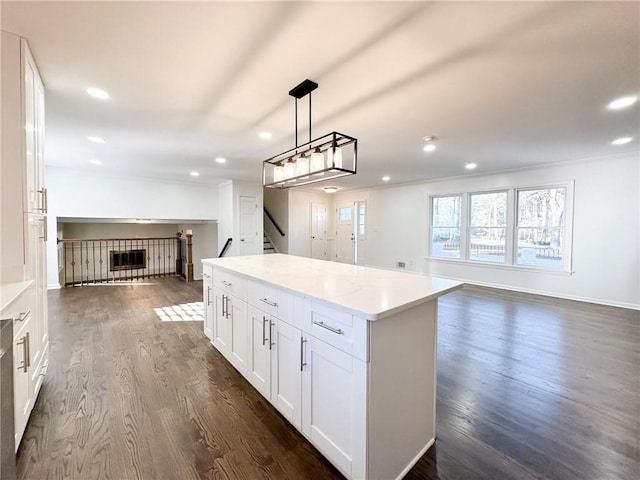 kitchen featuring a center island, hanging light fixtures, dark hardwood / wood-style floors, light stone countertops, and white cabinets